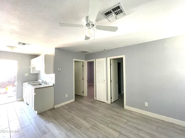 a view of a kitchen with wooden floor and a ceiling fan