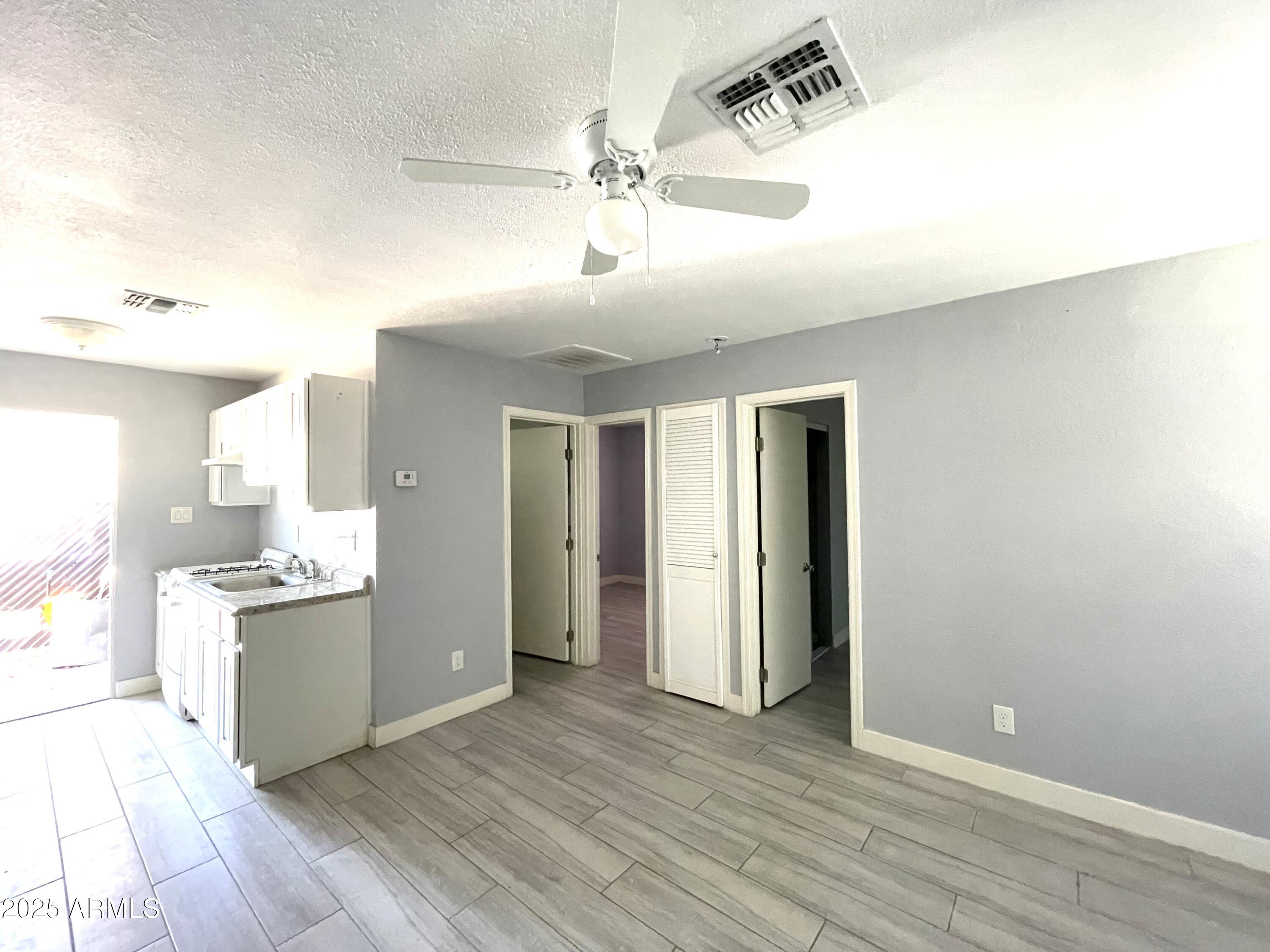 6801 East Avalon Drive, Unit D Scottsdale, AZ 85251 - Photo 2 of 7 a view of a kitchen with wooden floor and a ceiling fan