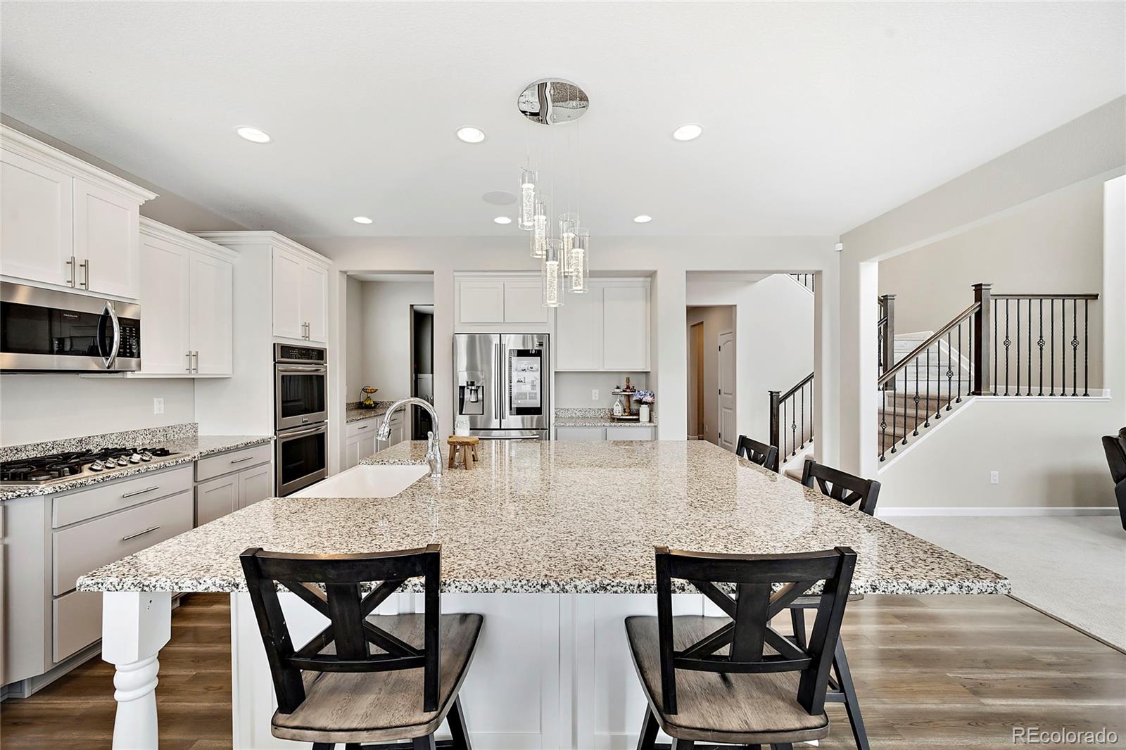 a kitchen with stainless steel appliances kitchen island granite countertop a dining table chairs and stove