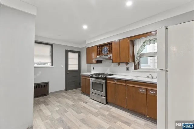 a kitchen with stainless steel appliances granite countertop a stove a sink dishwasher and a refrigerator