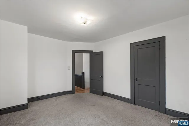 an empty room with closet and windows