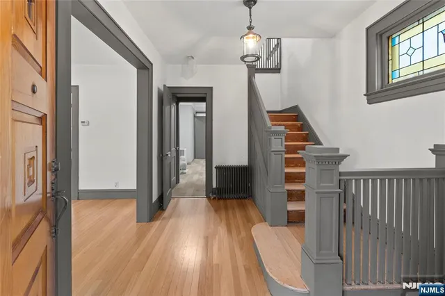 a view of a hallway with wooden floor and staircase