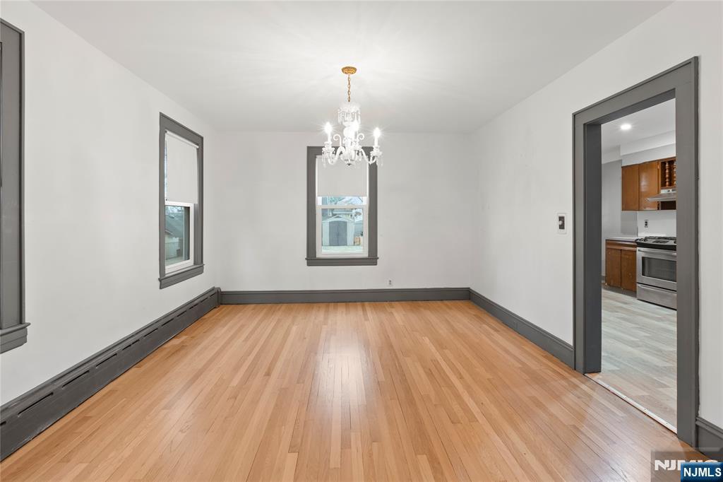 1114 Seib Avenue Elizabeth, NJ 07202 - Photo 10 of 31 a view of a room with wooden floor a ceiling fan and windows