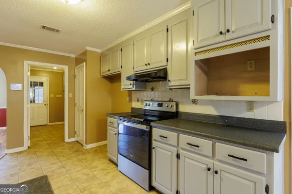 a kitchen with stainless steel appliances granite countertop a stove a sink and a refrigerator
