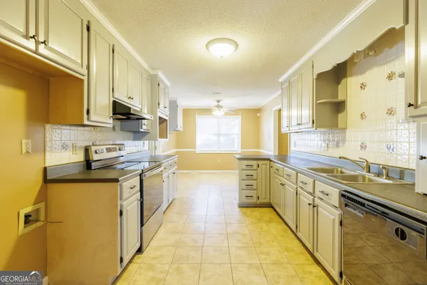 a large kitchen with stainless steel appliances granite countertop a sink and cabinets