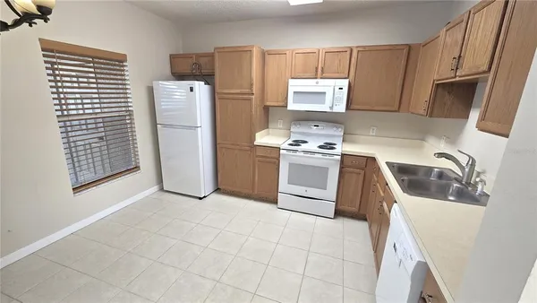 a kitchen with stainless steel appliances a sink a stove a refrigerator and cabinets