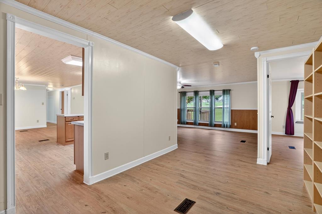 7757 Berry Road Burleson, TX 76028 - Photo 16 of 36 Open-concept interior featuring wood-finish flooring, light-toned walls, and a textured ceiling