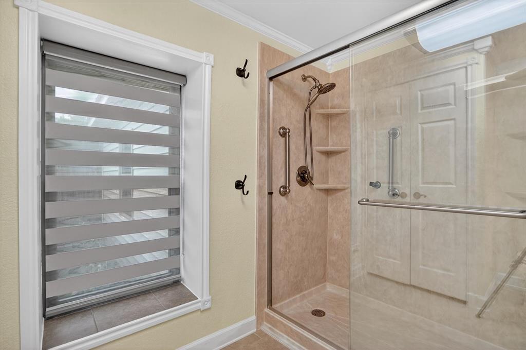 7757 Berry Road Burleson, TX 76028 - Photo 23 of 36 Framed shower enclosure featuring a bronze shower system, built-in shelving, and grab bars