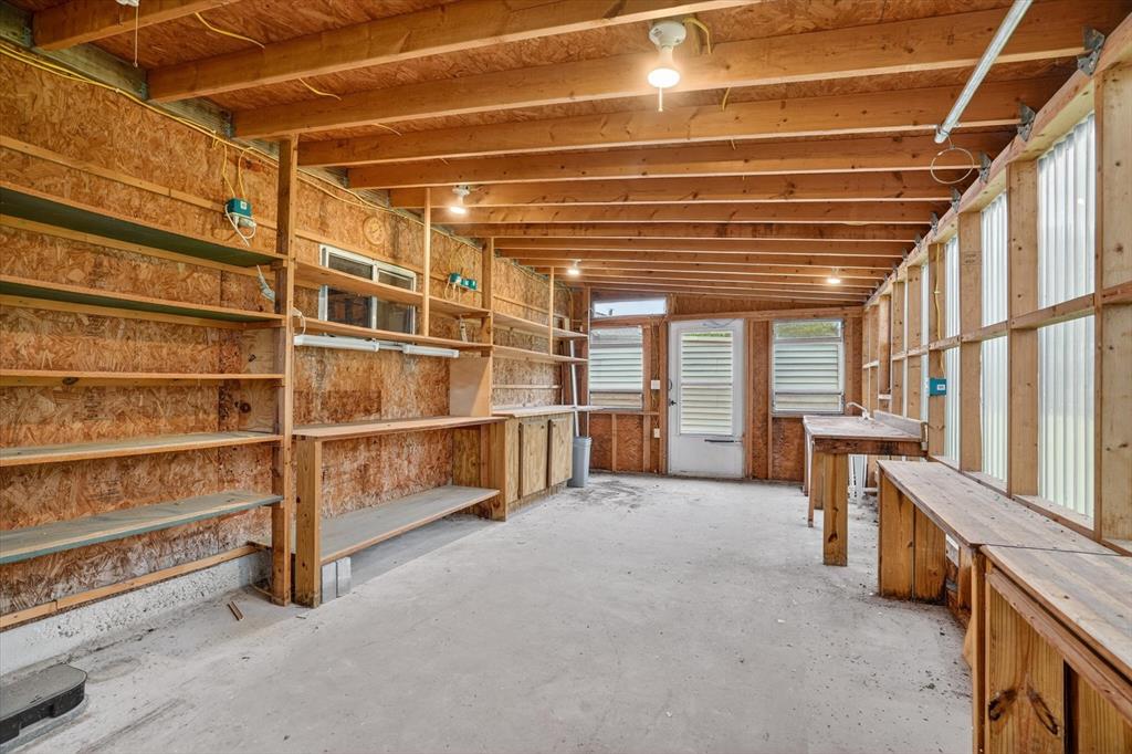 7757 Berry Road Burleson, TX 76028 - Photo 28 of 36 Spacious shop featuring extensive built-in shelving, durable concrete flooring, multiple workbenches, and natural light from translucent wall panels