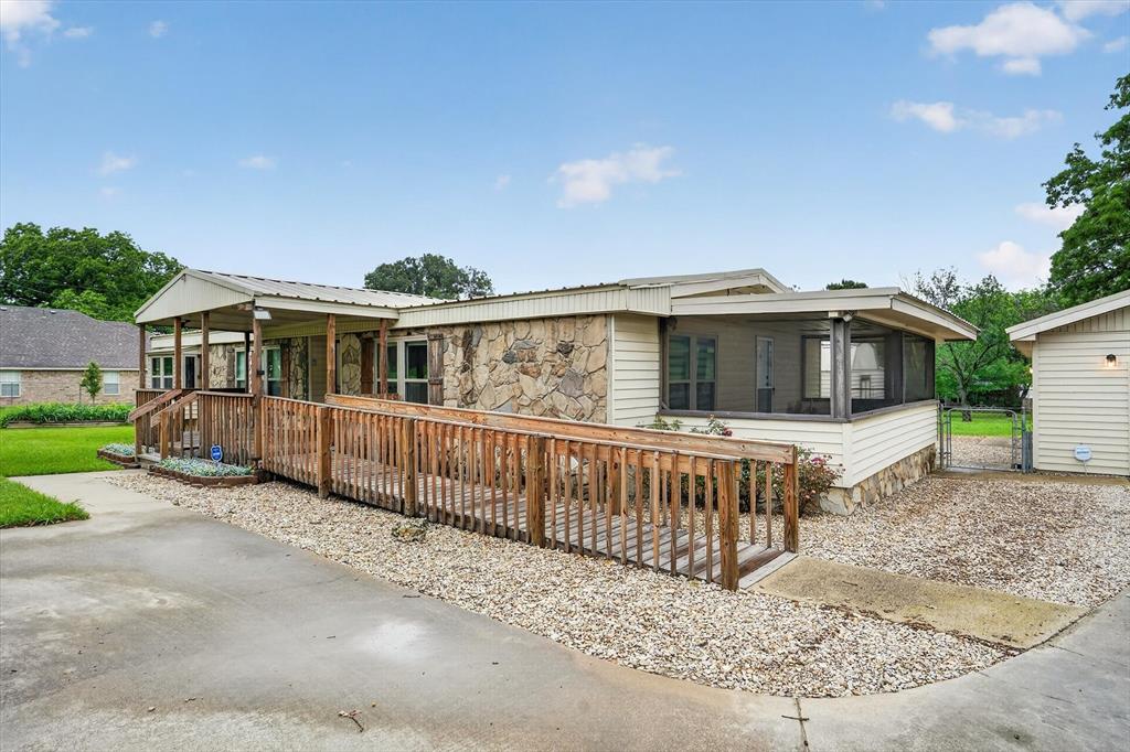 7757 Berry Road Burleson, TX 76028 - Photo 6 of 36 Exterior featuring stone veneer and horizontal siding, a covered porch, a screened porch, a wooden ramp, and a gravel and concrete driveway