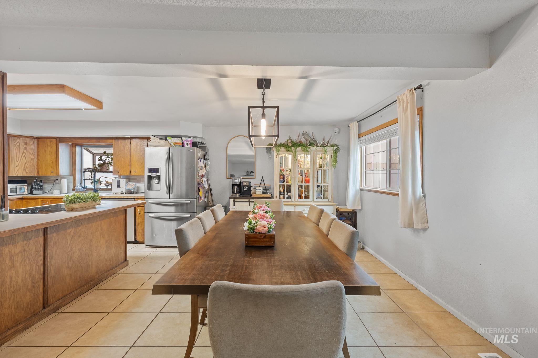 2119 Ripon Avenue Lewiston, ID 83501 - Photo 9 of 50 Dining area with tile flooring and a rectangular wood-finish table, illuminated by a suspended linear light fixture