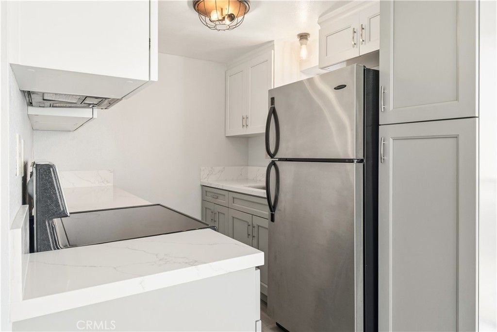 615 East Broadway, Unit 204 Long Beach, CA 90802 - Photo 4 of 27 a white refrigerator freezer and a wooden floor