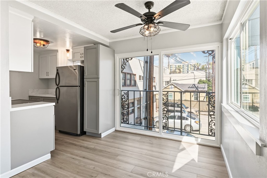 615 East Broadway, Unit 204 Long Beach, CA 90802 - Photo 7 of 27 a view of a kitchen with a stove wooden floor and a ceiling fan