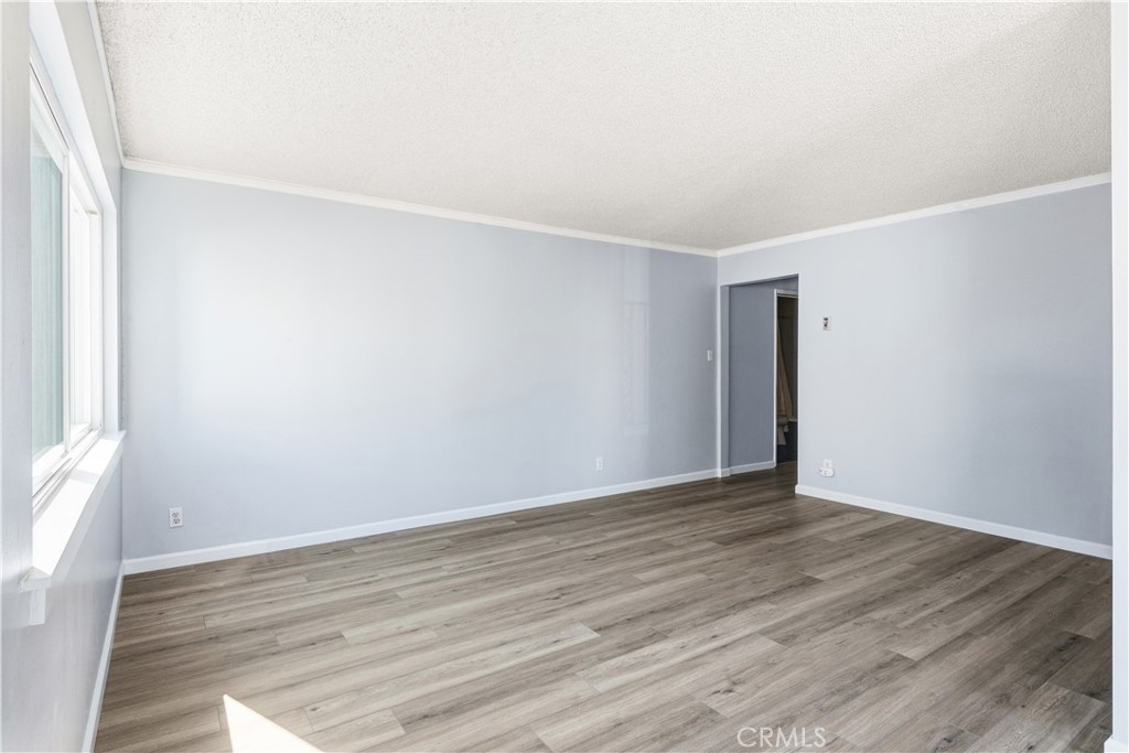 615 East Broadway, Unit 204 Long Beach, CA 90802 - Photo 9 of 27 a view of an empty room with wooden floor and a window