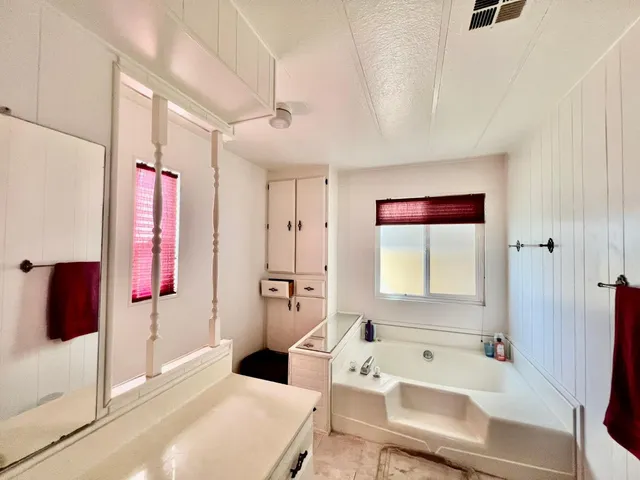 a bathroom with a tub sink and mirror