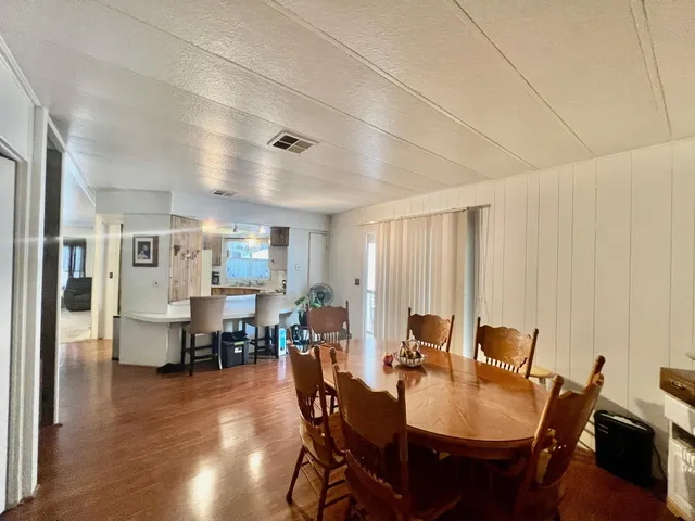a view of a a dining room with furniture window and wooden floor
