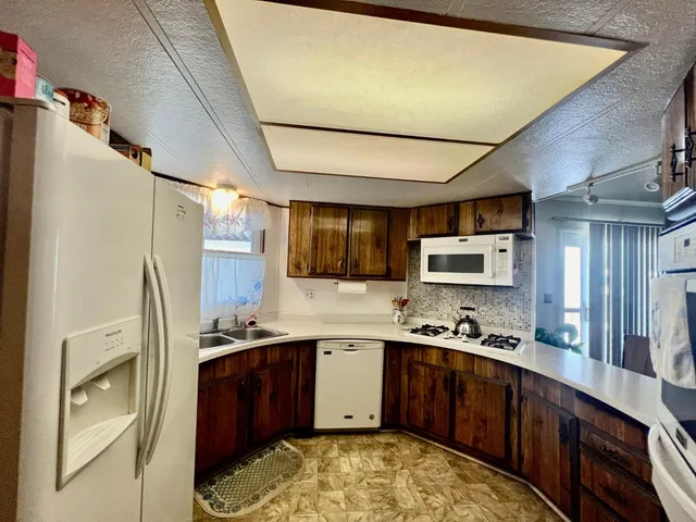 a kitchen with stainless steel appliances granite countertop a stove a sink dishwasher a refrigerator and a microwave