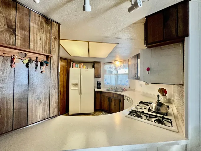 a kitchen with stainless steel appliances kitchen island granite countertop a refrigerator and a stove top oven