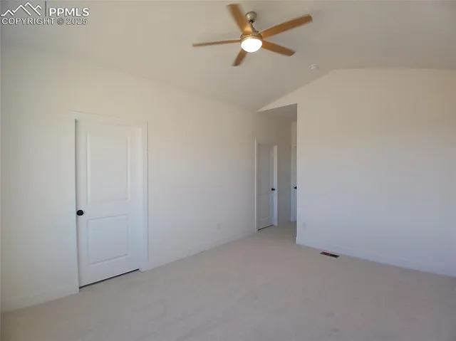 an empty room with a ceiling fan and a window