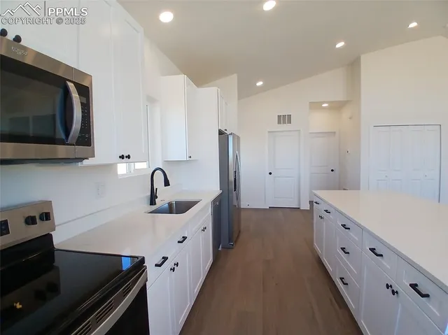 a kitchen with a sink stove and microwave