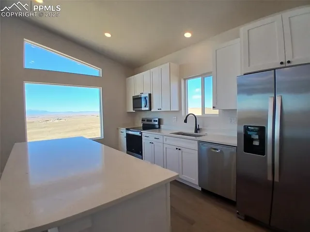 a kitchen with stainless steel appliances granite countertop a sink and a refrigerator