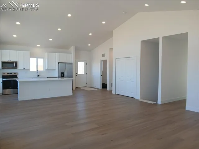 a view of a kitchen with a sink and a refrigerator