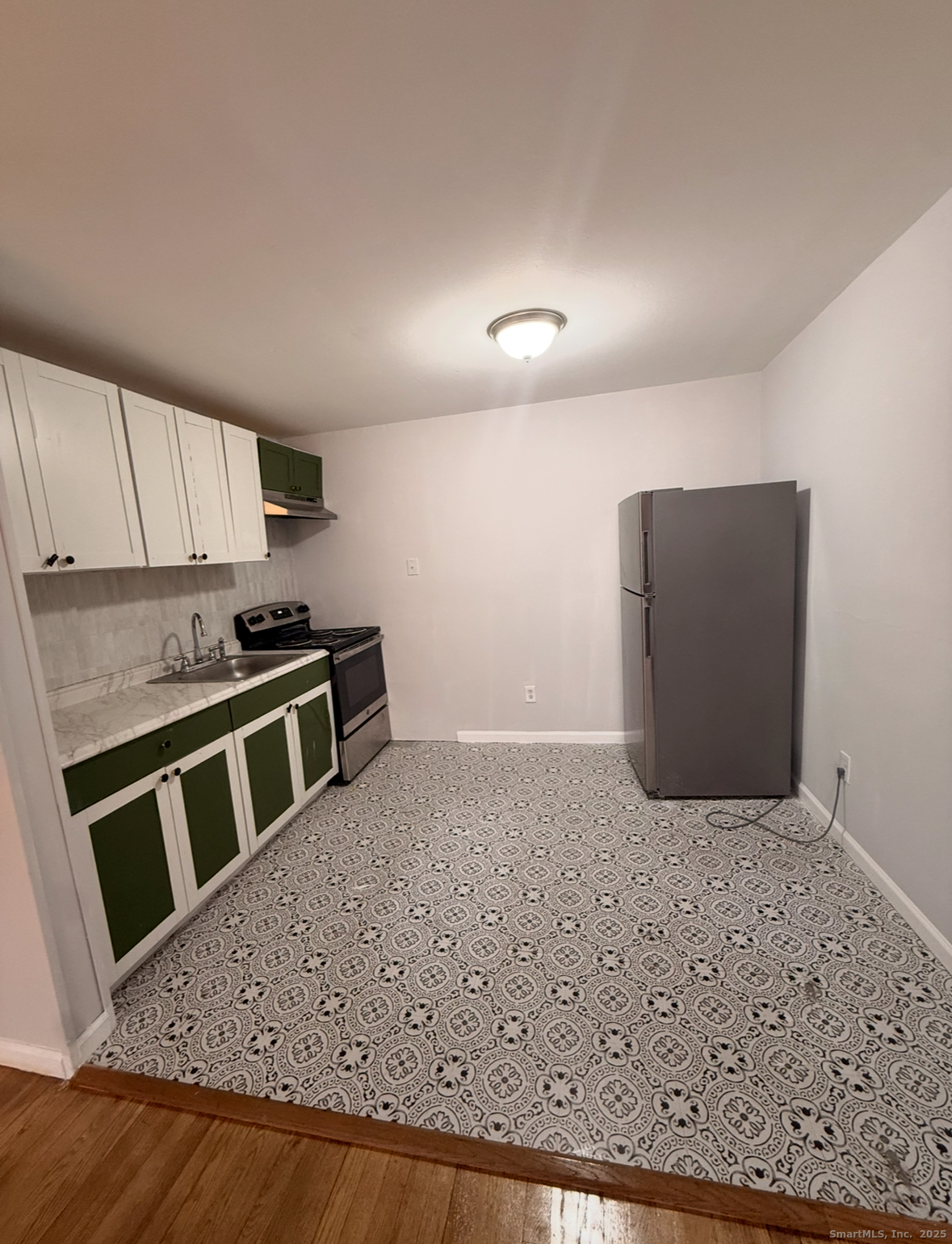 10 Highland Street, Unit H West Haven, CT 06516 - Photo 2 of 5 a kitchen with stainless steel appliances kitchen island granite countertop a stove a microwave and a refrigerator