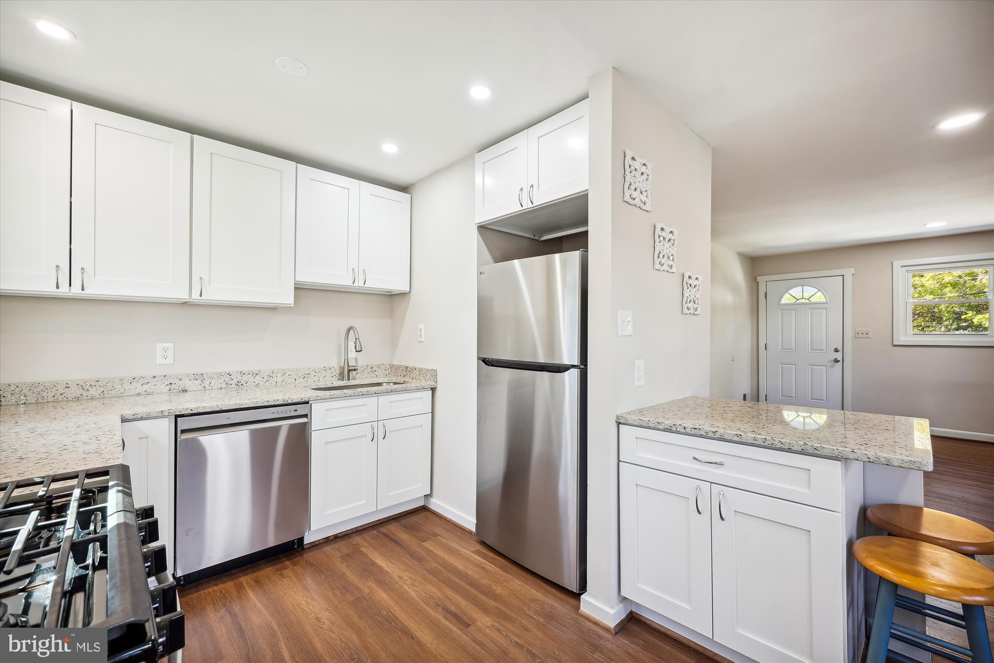 908 Whitehall Street Silver Spring, MD 20901 - Photo 7 of 76 a kitchen with stainless steel appliances granite countertop a refrigerator a stove and white cabinets with wooden floor