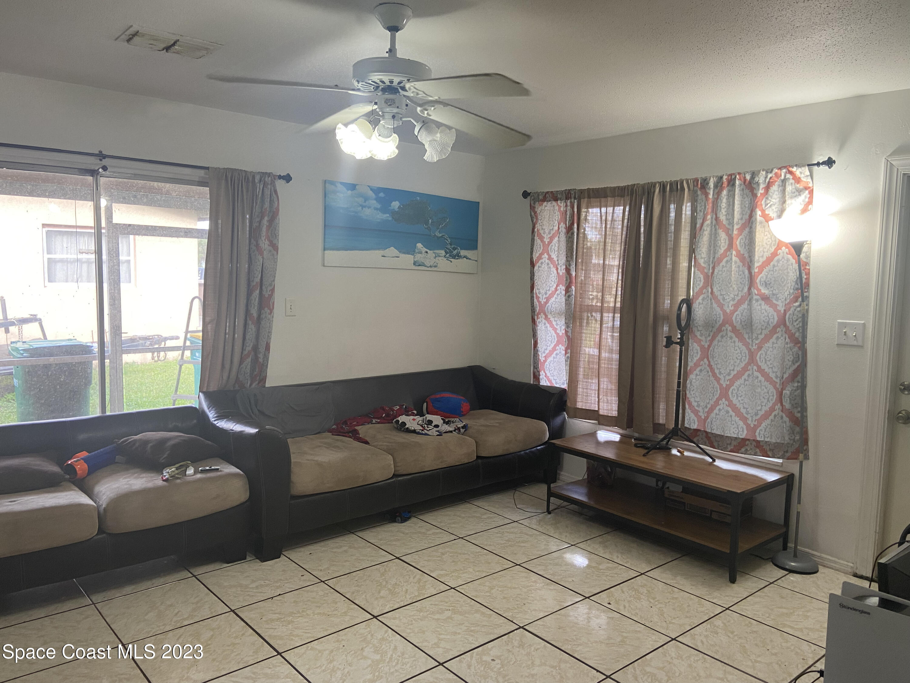2321 Sarno Road Melbourne, FL 32935 - Photo 2 of 9 a living room with furniture and a chandelier