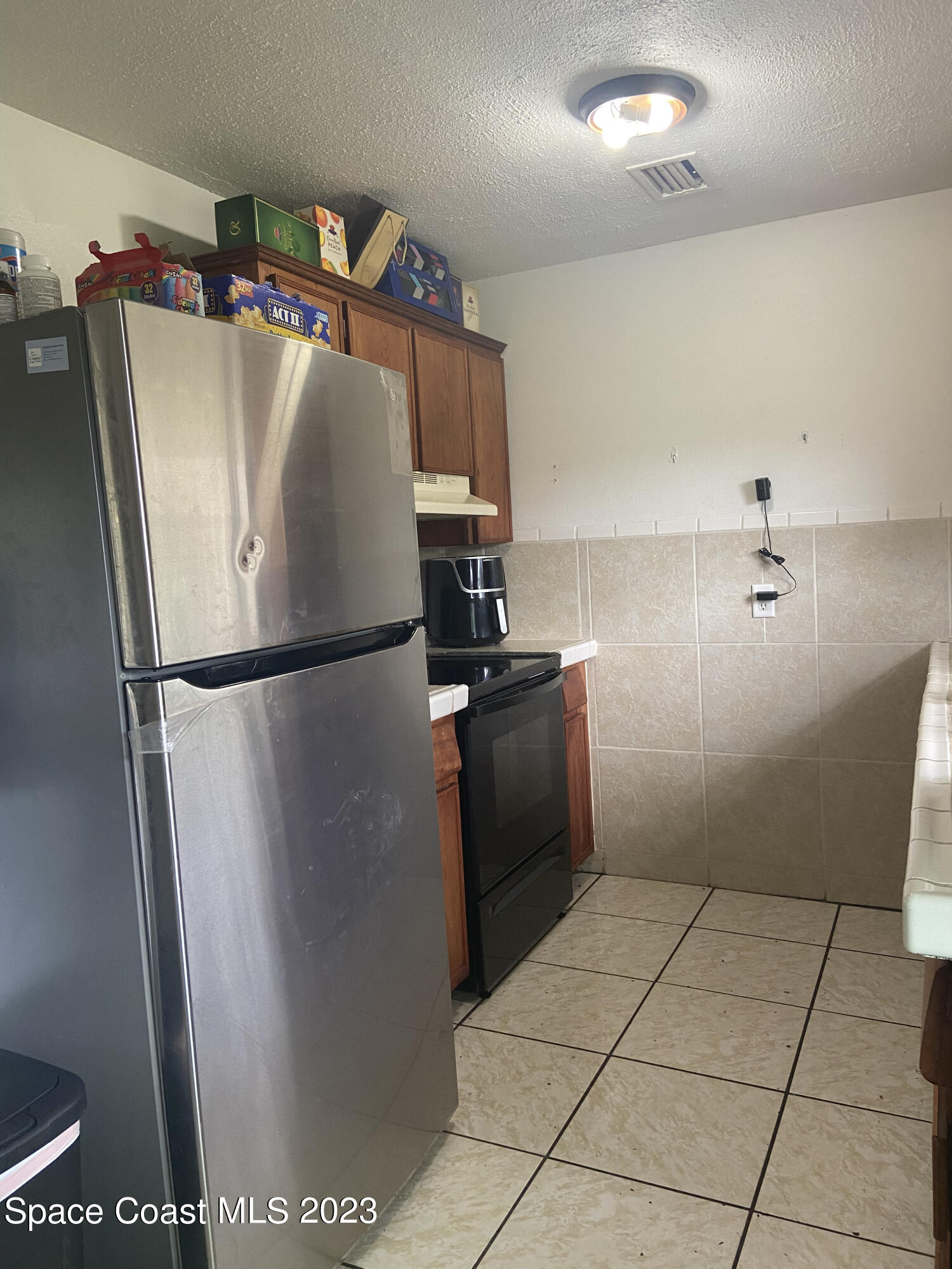 2321 Sarno Road Melbourne, FL 32935 - Photo 3 of 9 a kitchen with metallic refrigerator and washer