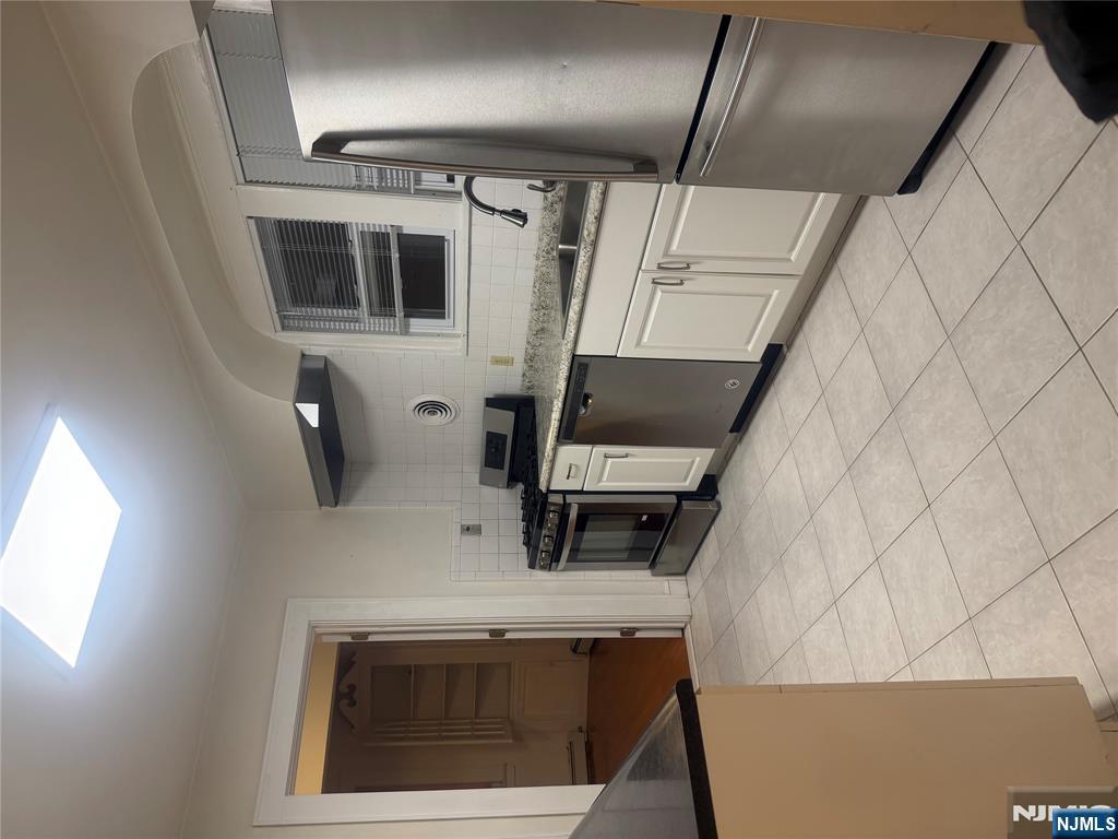 899 Maple Avenue, Unit 2 Ridgefield, NJ 07657 - Photo 8 of 8 a kitchen with a stove a sink and a refrigerator
