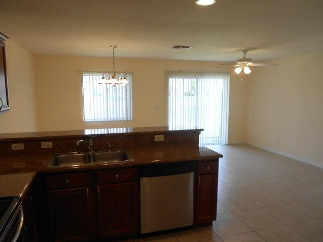 2218 Rockport Road Port St. Lucie, FL 34953 - Photo 11 of 20 a kitchen with granite countertop a sink a window and cabinets