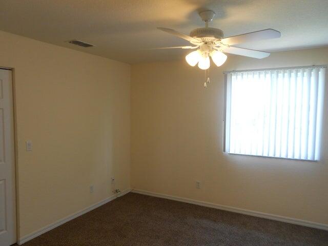 2218 Rockport Road Port St. Lucie, FL 34953 - Photo 14 of 20 an empty room with a window and a chandelier fan