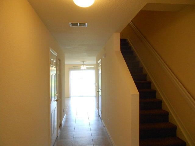 2218 Rockport Road Port St. Lucie, FL 34953 - Photo 3 of 20 a view of a hallway with wooden floor and staircase