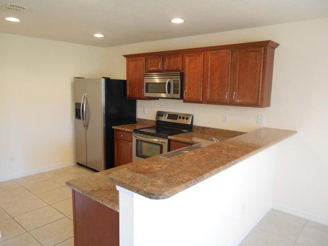 2218 Rockport Road Port St. Lucie, FL 34953 - Photo 8 of 20 a kitchen with wooden cabinets a refrigerator and a sink