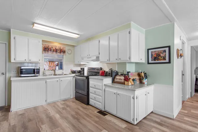 a kitchen with white cabinets and white appliances