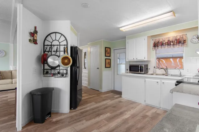 a kitchen with stainless steel appliances granite countertop a refrigerator a stove and a wooden floors