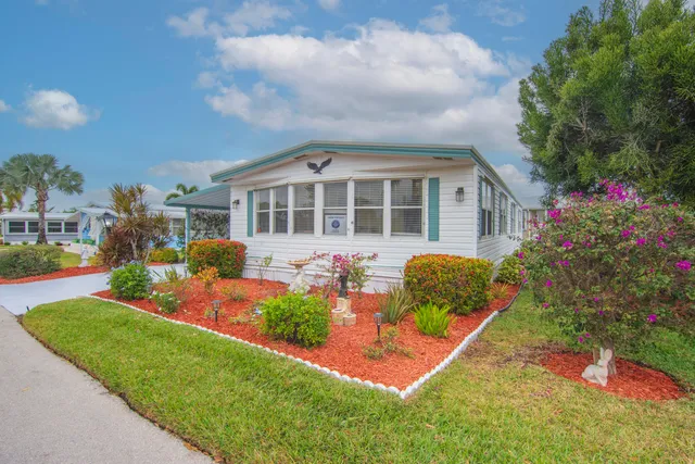 a front view of a house with a yard and potted plants