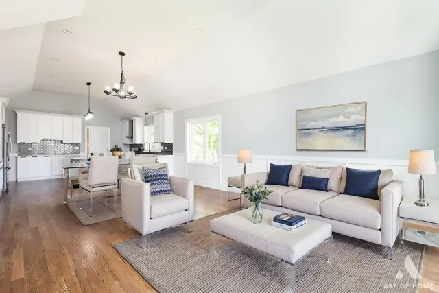 an empty room with wooden floor chandelier and windows