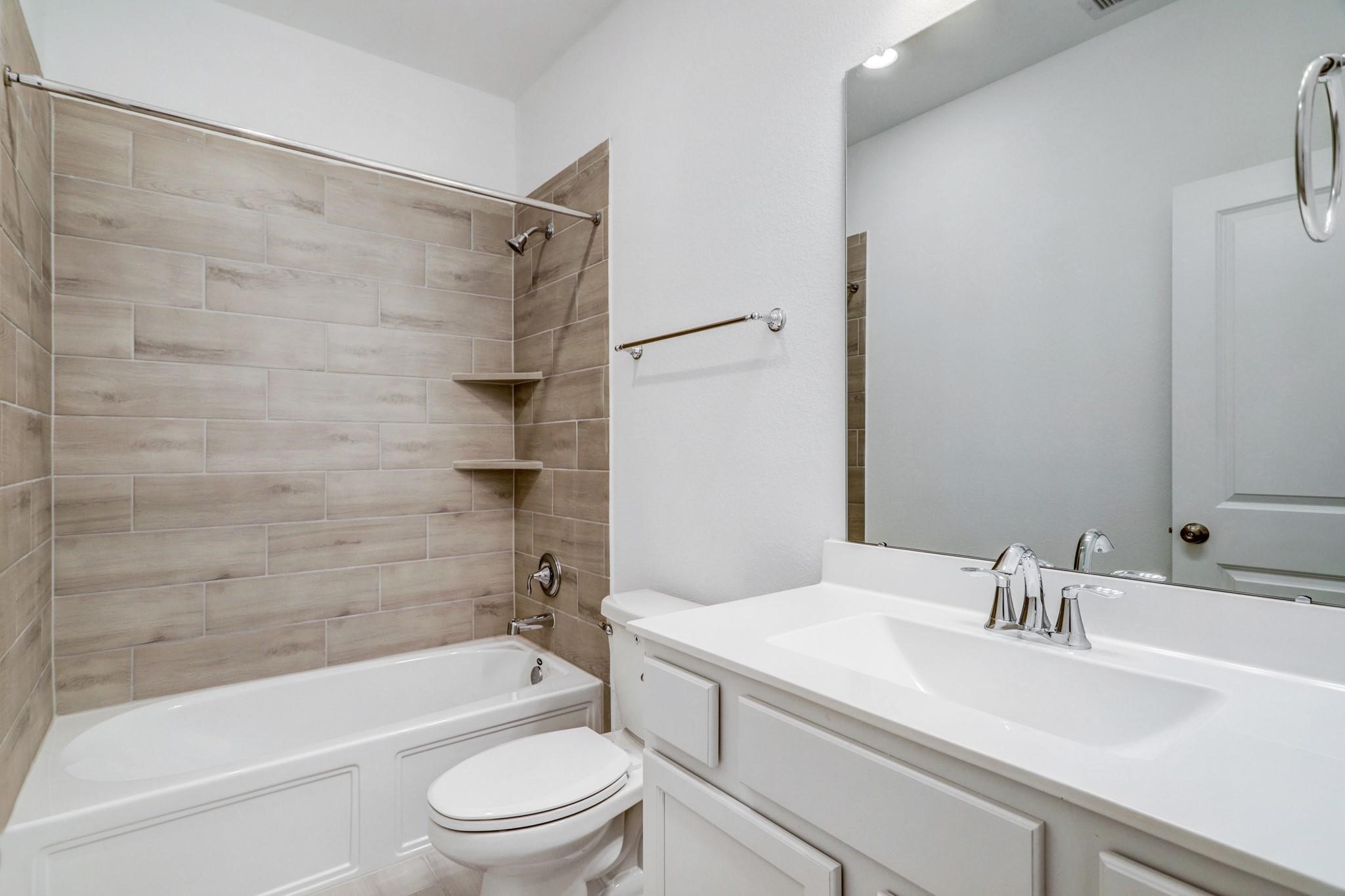 21015 Morning Nectar Lane Cypress, TX 77433 - Photo 14 of 34 a bathroom with a granite countertop bathtub shower sink vanity mirror and toilet