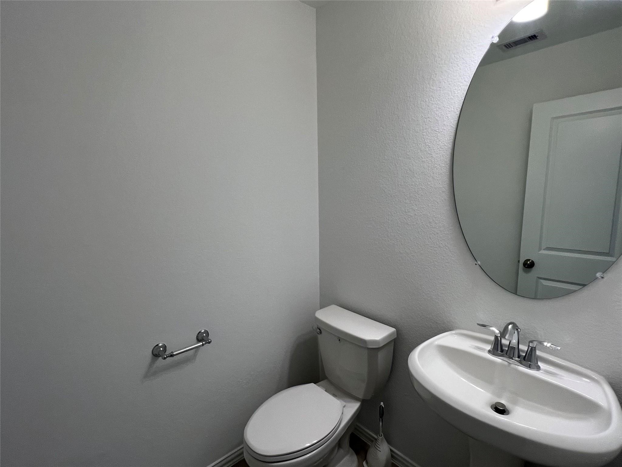 21015 Morning Nectar Lane Cypress, TX 77433 - Photo 31 of 34 a bathroom with a sink a toilet and mirror