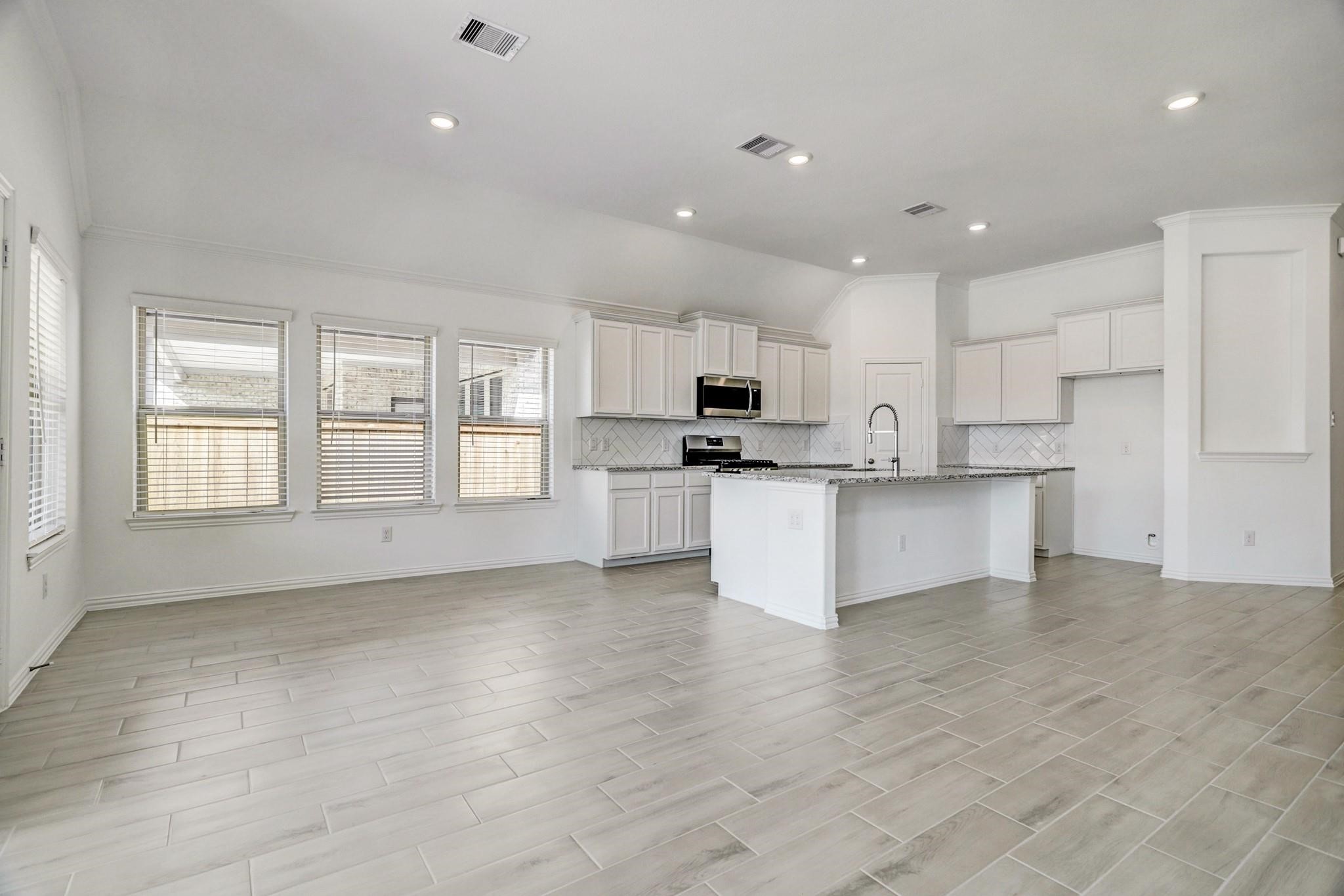 21015 Morning Nectar Lane Cypress, TX 77433 - Photo 6 of 34 a large kitchen with cabinets and wooden floor