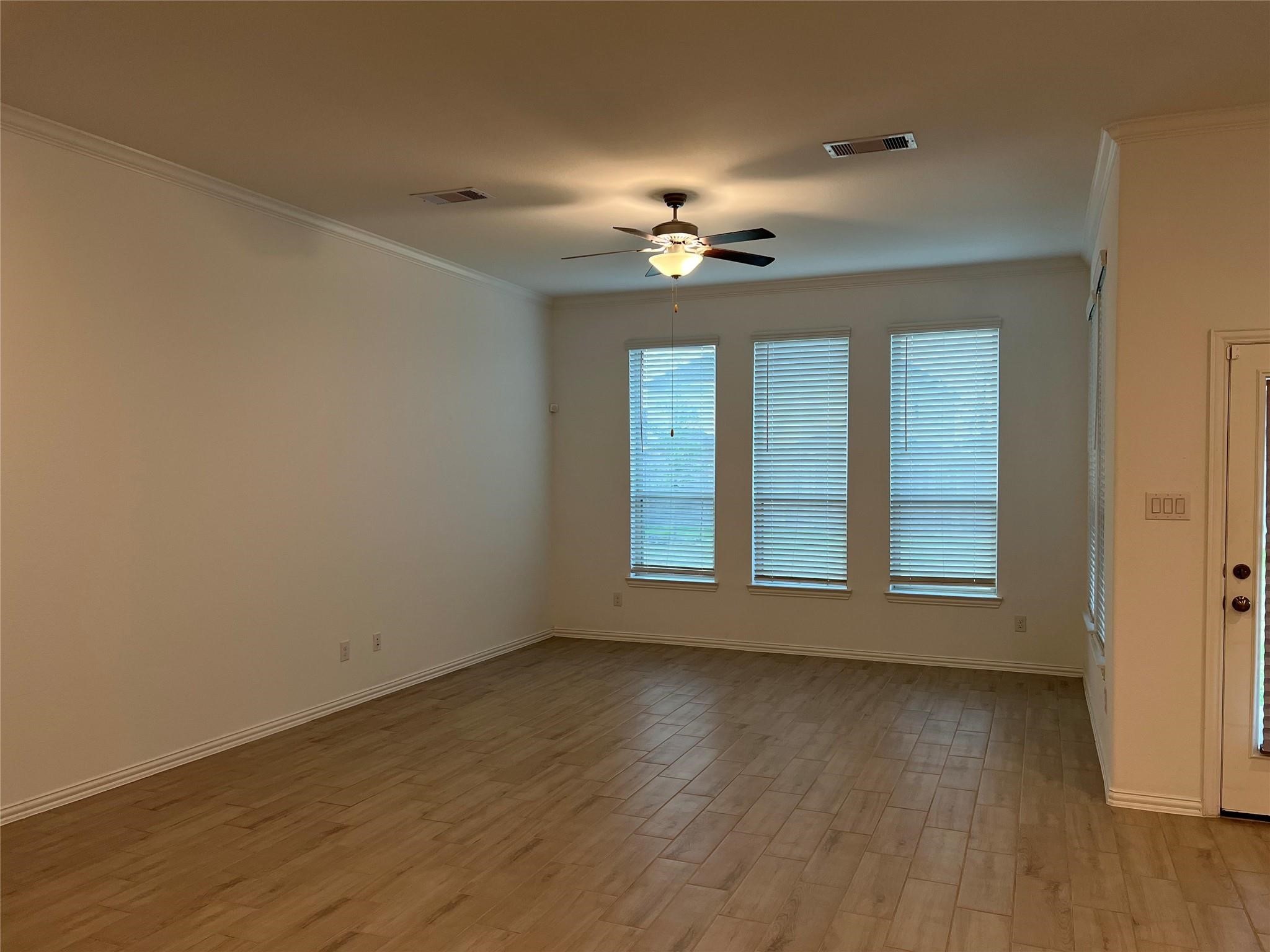21015 Morning Nectar Lane Cypress, TX 77433 - Photo 9 of 34 a view of an empty room with a window and wooden floor