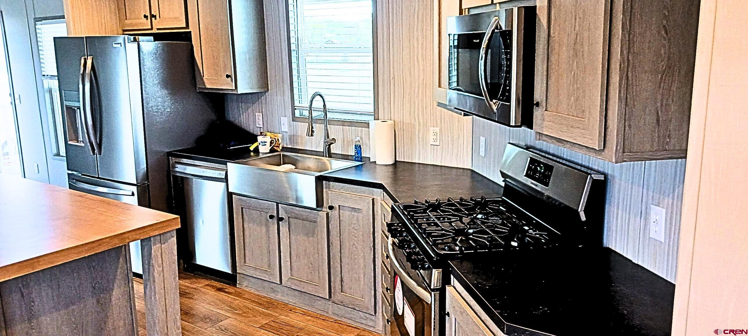 62650 Lasalle Road, Unit 317 Montrose, CO 81403 - Photo 2 of 23 a kitchen with stainless steel appliances granite countertop a stove and a refrigerator
