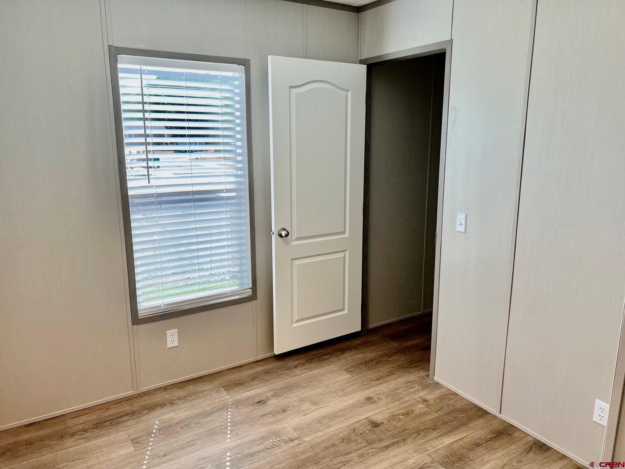 62650 Lasalle Road, Unit 317 Montrose, CO 81403 - Photo 22 of 23 a view of an empty room with wooden floor and a window