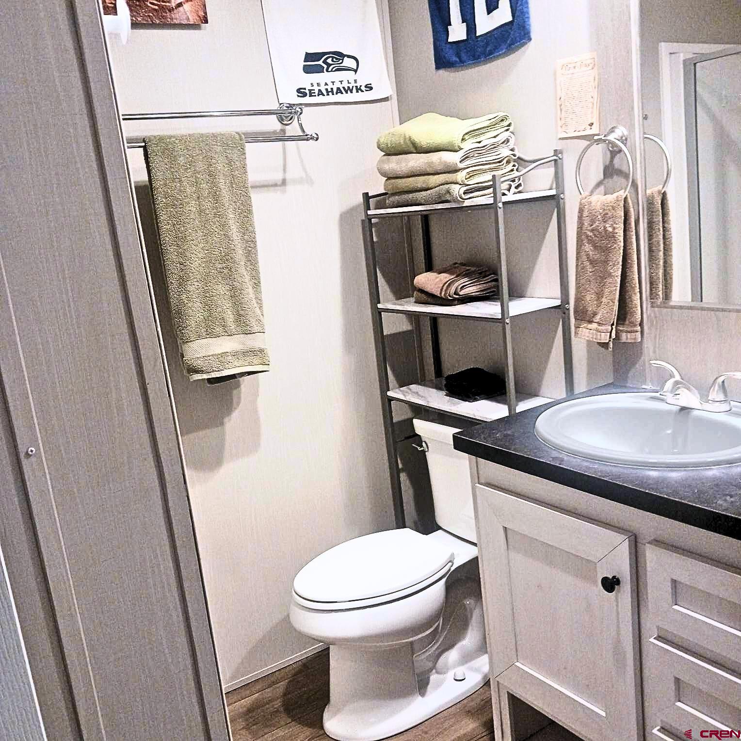 62650 Lasalle Road, Unit 317 Montrose, CO 81403 - Photo 10 of 23 a bathroom with a granite countertop toilet sink and mirror