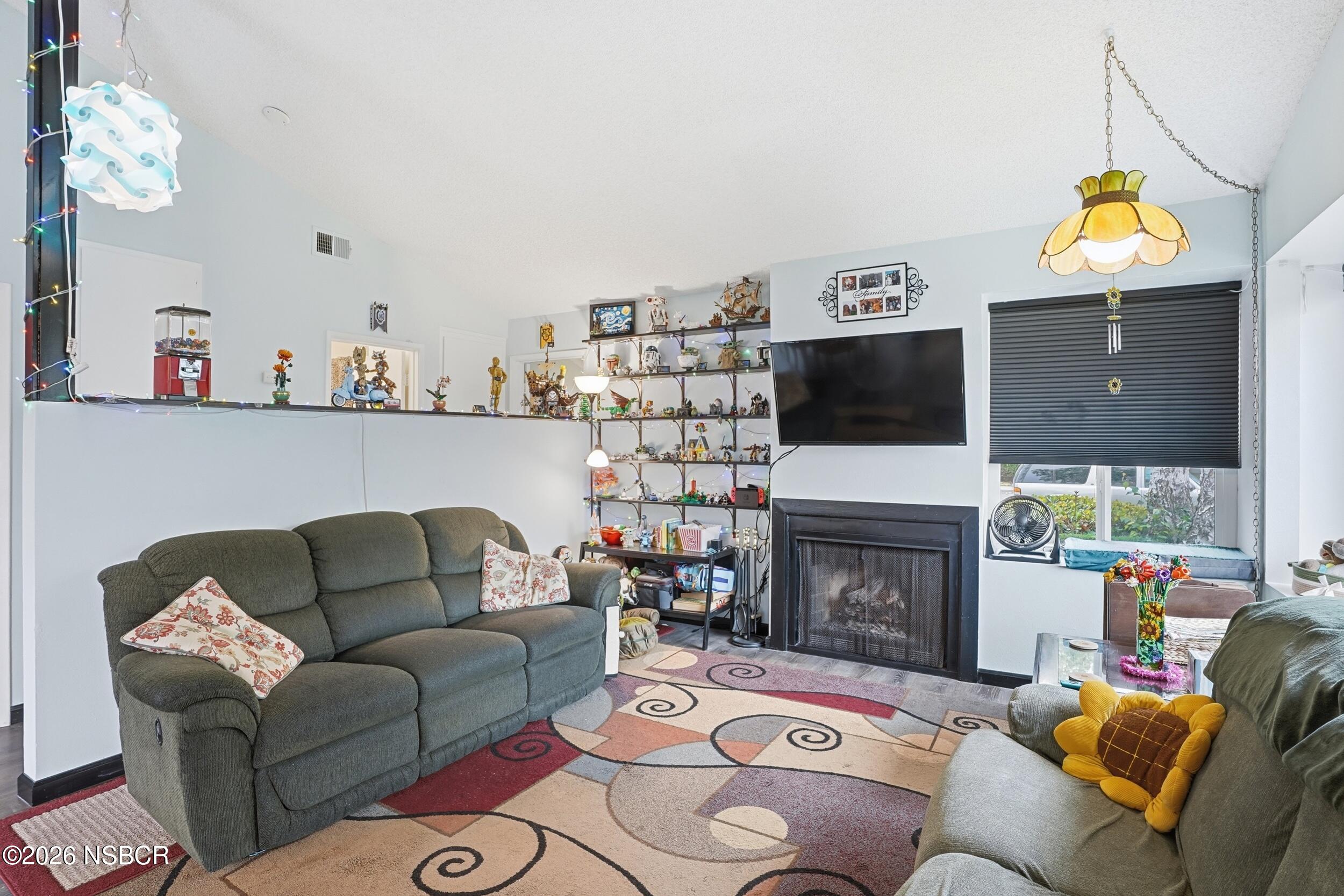 218 North R Street Lompoc, CA 93436 - Photo 7 of 24 a living room with furniture a fireplace and a flat screen tv