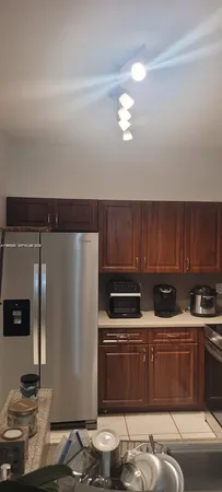 a kitchen with stainless steel appliances wooden cabinets and a stove top oven
