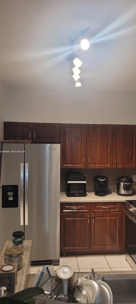 8331 Southwest 124th Avenue, Unit 10114 Miami, FL 33183 - Photo 17 of 19 a kitchen with stainless steel appliances wooden cabinets and a stove top oven