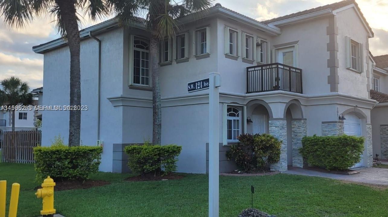 8331 Southwest 124th Avenue, Unit 10114 Miami, FL 33183 - Photo 6 of 19 a front view of a house with a garden and plants